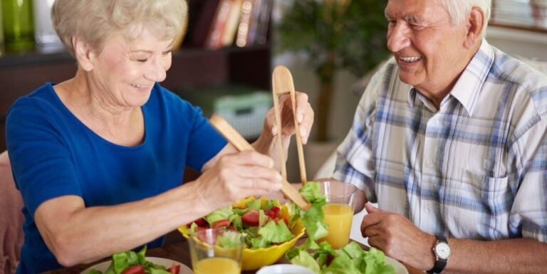 Elderly Couple Eating Balanced Meals At Assisted Living Facility
