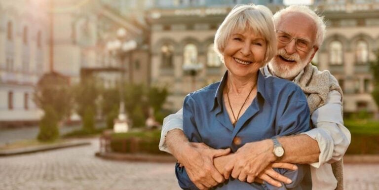 Adult Daughter Embracing Elderly Mother Outdoors at Assisted Living Facility